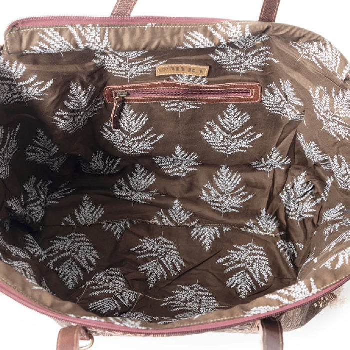 A stylish tote bag in brown and white, adorned with a distinctive pattern, great for shopping or daily activities.