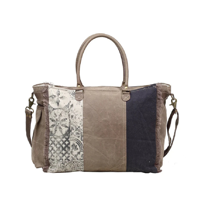 Canvas vintage bag embellished with multiple patches, highlighting a distinctive and creative design.