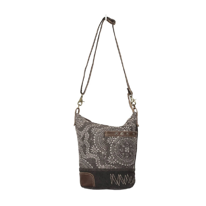 Leather bag adorned with a paisley print, complemented by a brown strap for a sophisticated touch.