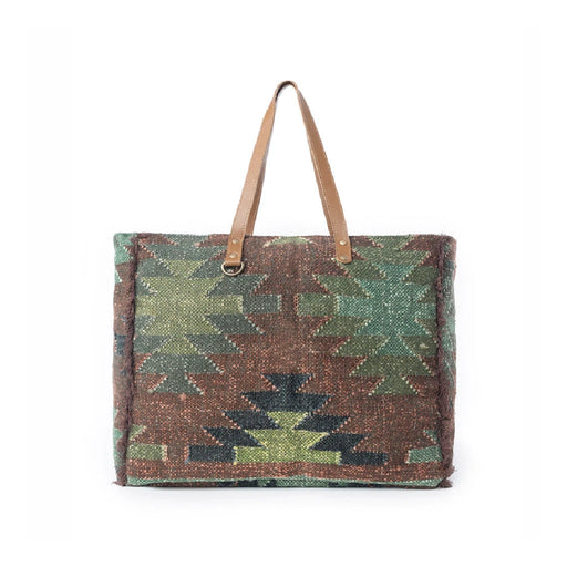 A large kilim bag featuring a woven pattern in green and brown tones, showcasing intricate textile craftsmanship.