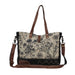 The Myra Bag Mystique Messenger Bag features upcycled woven canvas with rich leather accents. 