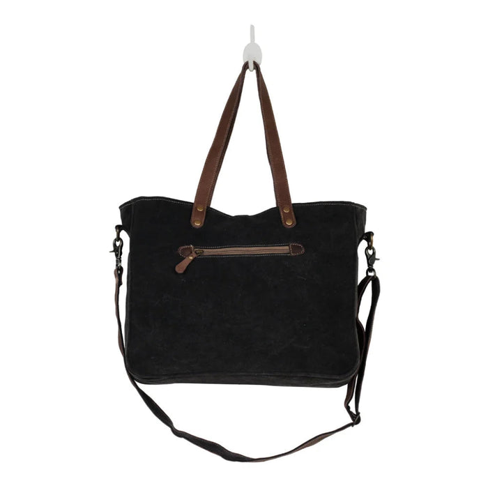 The Myra Bag Mystique Messenger Bag features upcycled woven canvas with rich leather accents. 