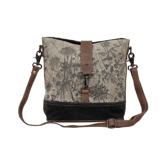 Floral print canvas bag featuring a brown strap and a brown leather shoulder strap for added style and comfort.