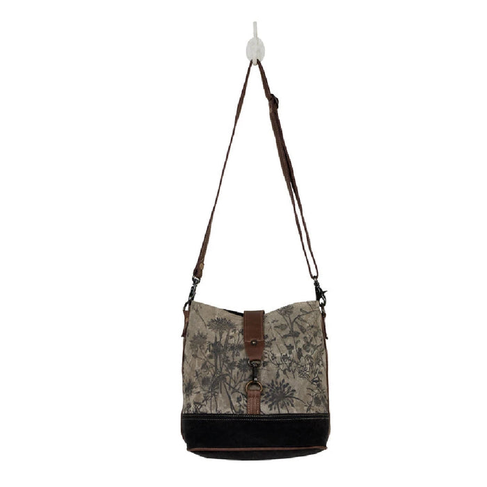 Floral canvas bag with a brown strap and a leather shoulder strap, combining practicality with a stylish design.