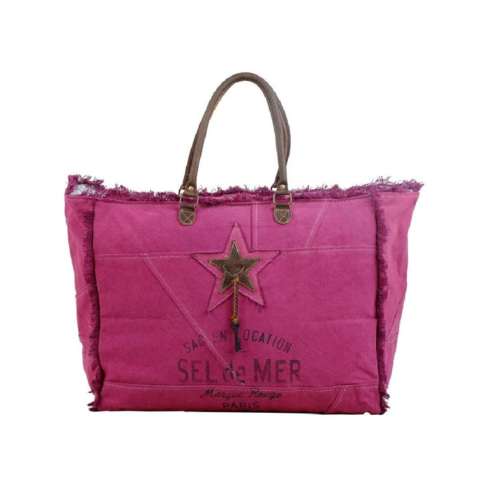 A pink tote bag featuring a prominent star design on the front.