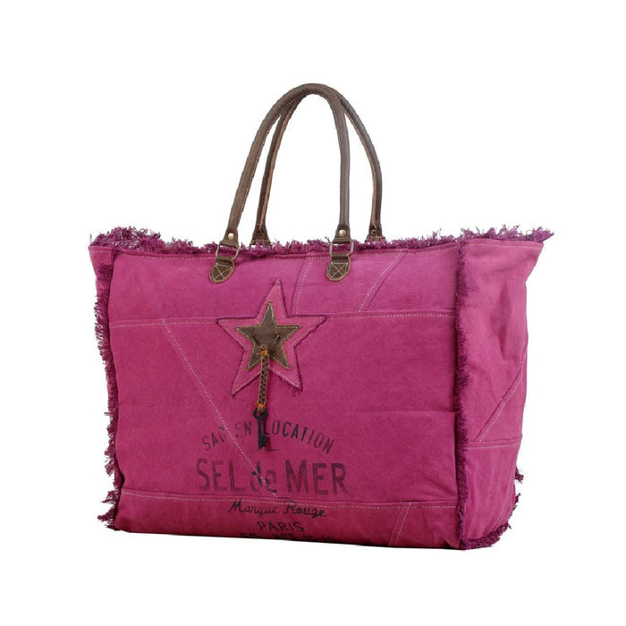 A stylish pink tote bag adorned with a star emblem.