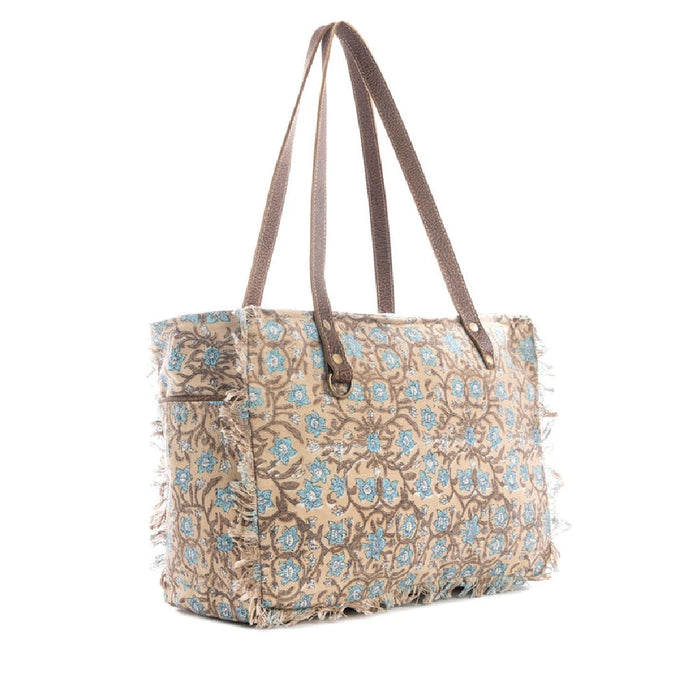 A stylish tote bag featuring a blue and brown floral pattern, perfect for carrying essentials with a touch of elegance.