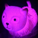 Pink cat-shaped object glowing under a black light