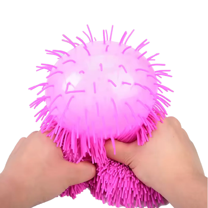 Pink spiky ball being held by hands on a white background