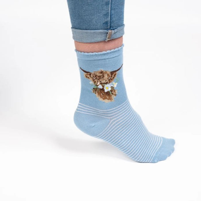  Blue socks adorned with a whimsical cow graphic.