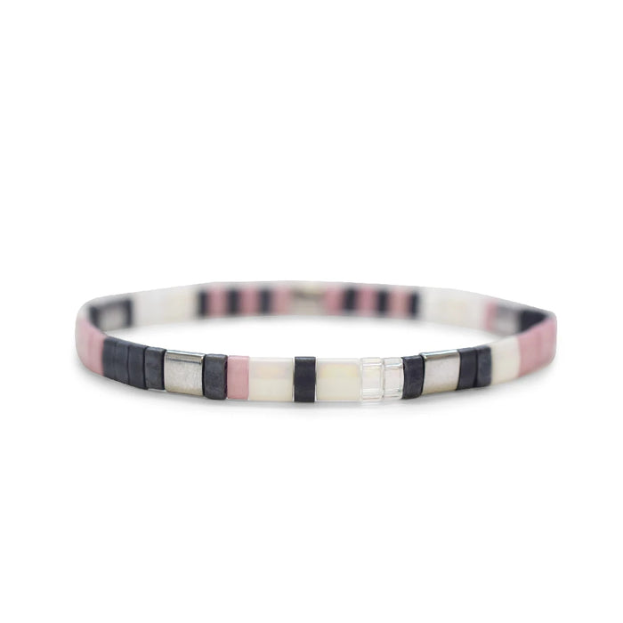 A stylish bracelet composed of black, white, and pink beads in a decorative arrangement.