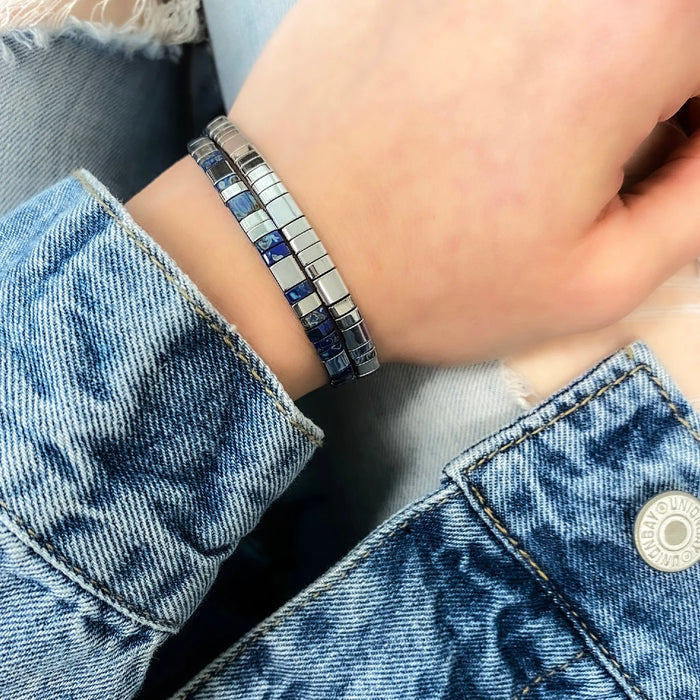A bracelet with blue and white stripes and a silver clasp.