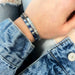 A bracelet with blue and white stripes and a silver clasp.