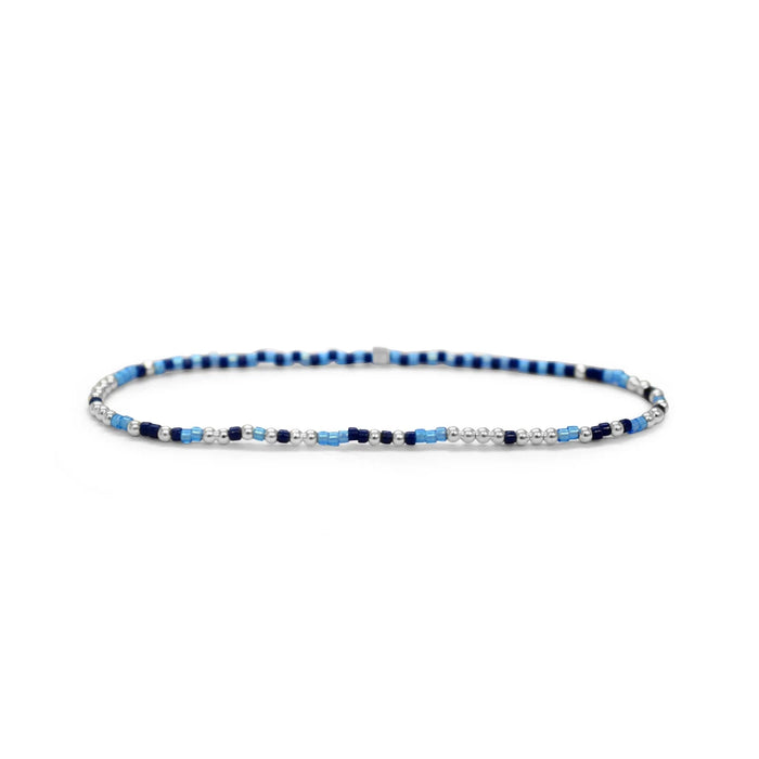 A bracelet featuring alternating blue and white beads arranged in a decorative pattern.