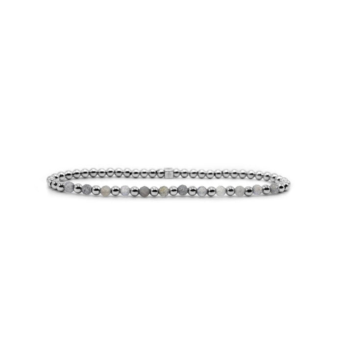 A stylish bracelet adorned with a pattern of white and black stones, showcasing a modern design.