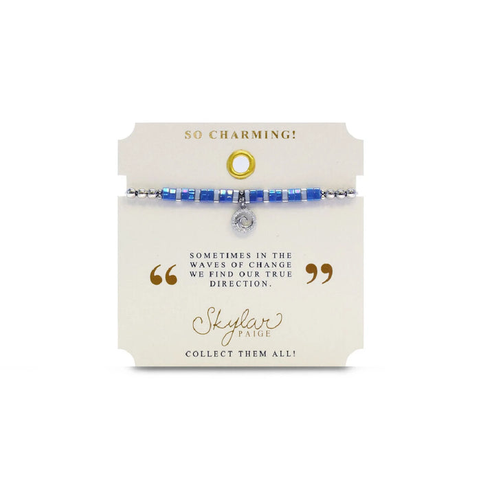 A bracelet with vibrant blue stones and a delicate silver charm, showcasing a blend of elegance and charm.