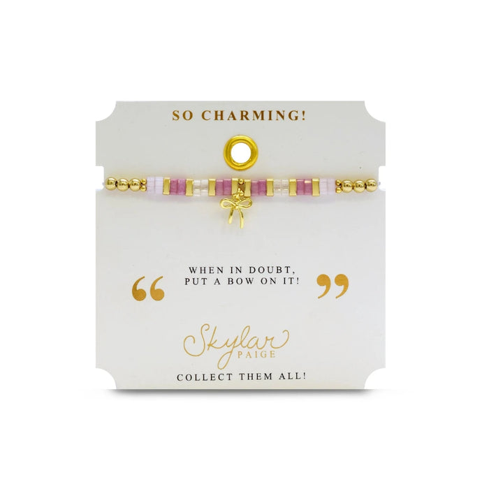 An elegant pink and gold bracelet with a bow detail, combining playful and sophisticated elements in its design.