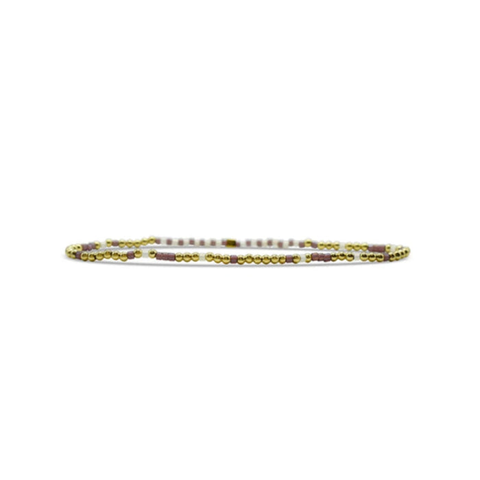 A beaded bracelet featuring a design of alternating gold and white beads.