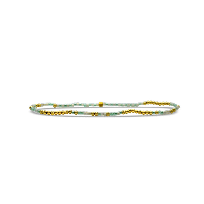 Gold and green beaded bracelet featuring a prominent gold bead at its center.