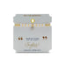 A stylish bracelet composed of gold and white beads, highlighted by a decorative cross charm.