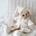 Teddy bear in pajamas sitting on a white blanket