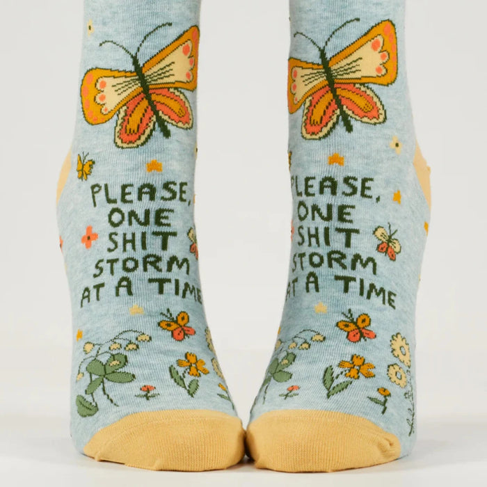Pair of socks with butterfly design and text on a light blue background