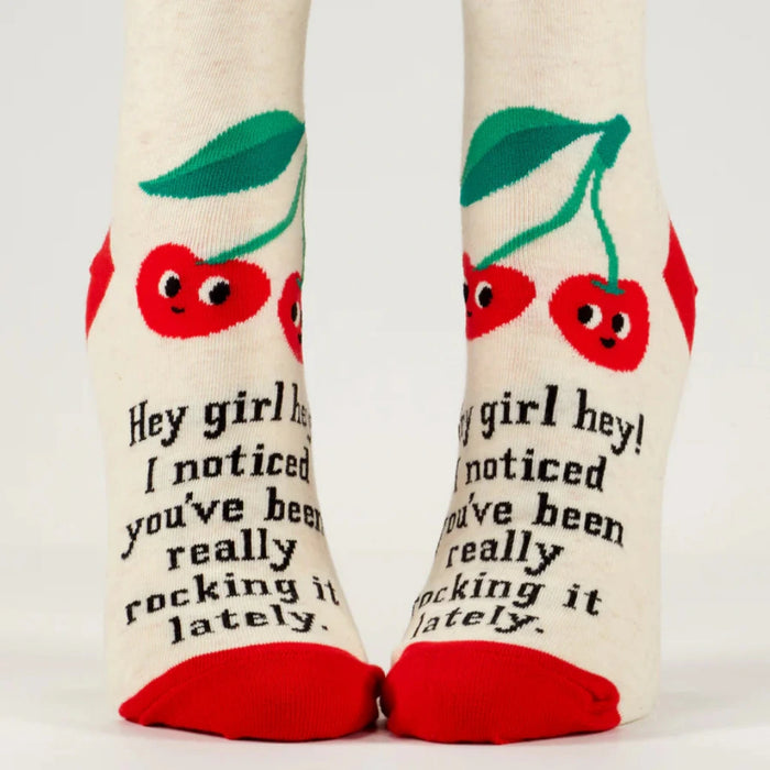 Pair of socks with cherry design and text on a white background