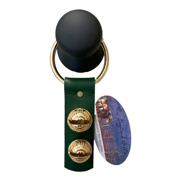 Keychain with black ball, gold rings, green leather strap, and map design on a white background