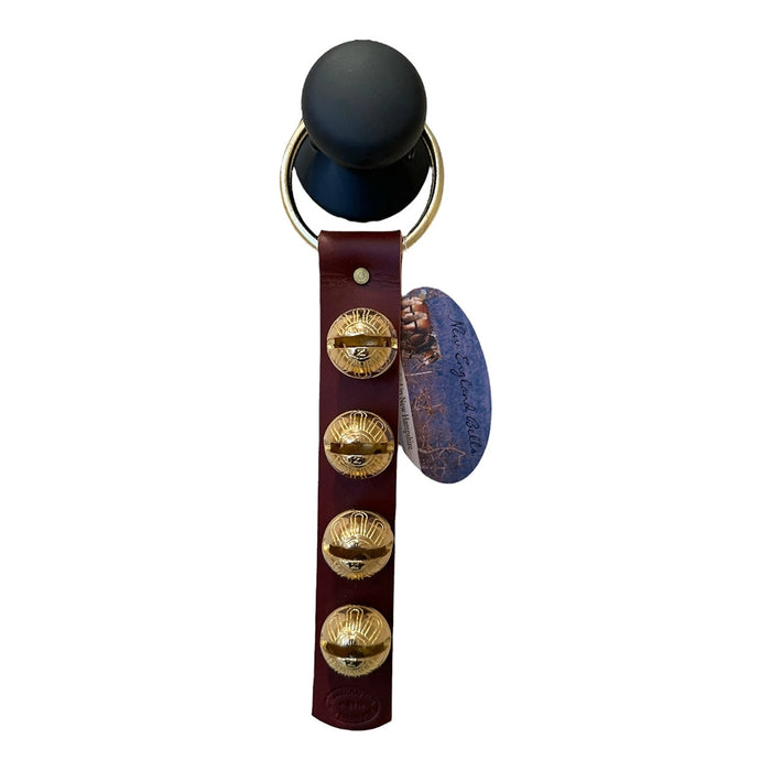 Black object with gold buttons and a leather strap on a white background