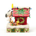 Side view of Snoopy and Woodstock decorating the doghouse with multicolored lights and a green wreath.