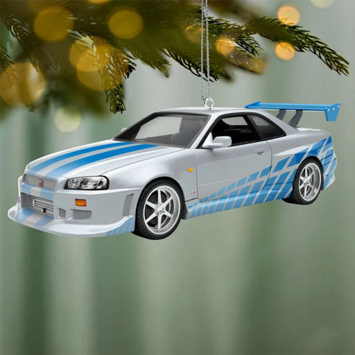Car-shaped Christmas ornament with blue stripes hanging on a tree.