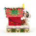 Side view of Snoopy decorating the doghouse with multicolored lights and a green wreath.