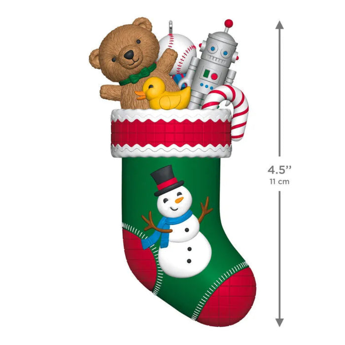 Illustration of a Christmas stocking with toys and a snowman design, with dimensions indicated.