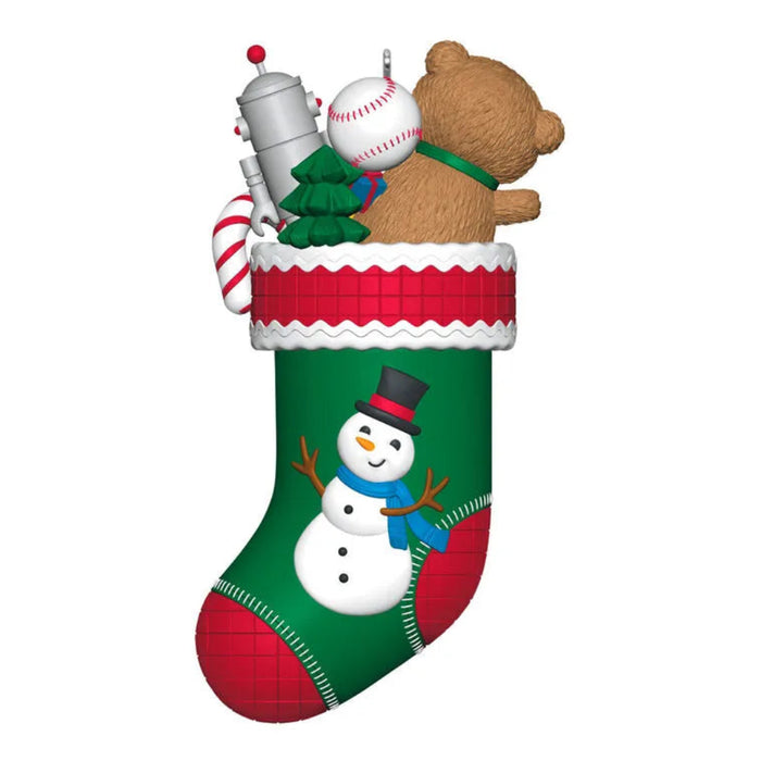 Christmas stocking with toys including a teddy bear, robot, and snowman on a white background
