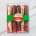 Sweet Jubilee Chocolate Covered Caramel Pretzel Rod Box with milk, dark, and white chocolate rods decorated with holiday sprinkles and green ribbon.