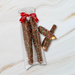 Sweet Jubilee Holiday Milk Chocolate Covered Caramel Pretzel Rods in clear bag with red ribbon.