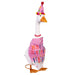 A duck in a vibrant birthday hat is perched on a lawn, adding a playful touch to a festive scene.