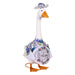 A duck sporting a shirt and hat stands on grassy ground, presenting a lighthearted and entertaining image.
