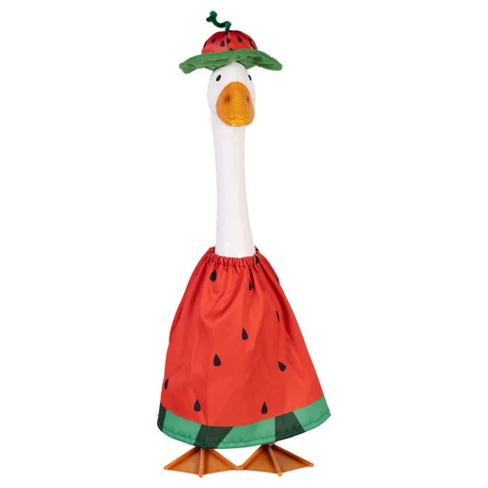 A whimsical duck wearing a watermelon dress poses in a colorful garden, surrounded by blooming flowers and plants.