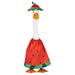 A whimsical duck wearing a watermelon dress poses in a colorful garden, surrounded by blooming flowers and plants.