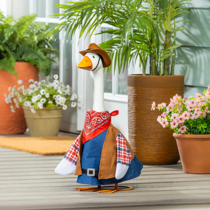 A duck dressed in a cowboy outfit stands on a porch, showcasing a playful and whimsical scene.