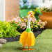 A duck dressed in a colorful dress, standing gracefully on a grassy surface.