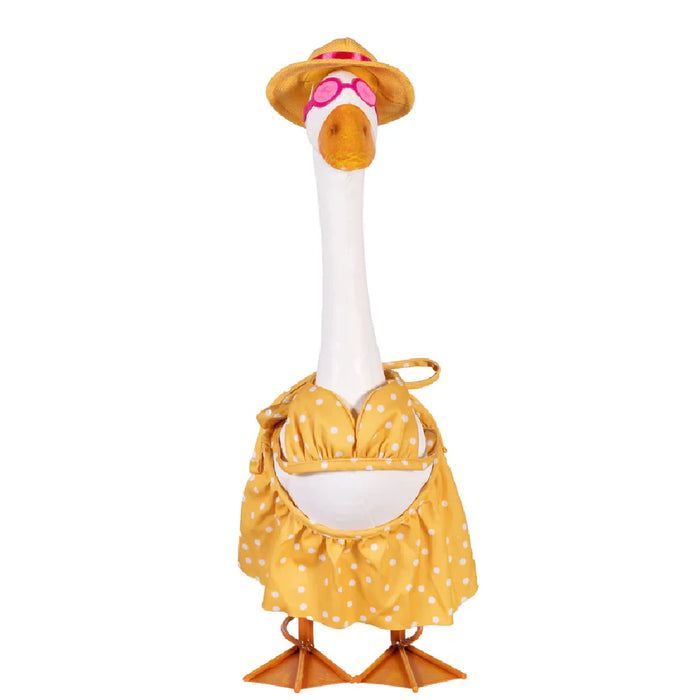 A duck dressed in a colorful dress and hat stands in a vibrant garden filled with flowers.