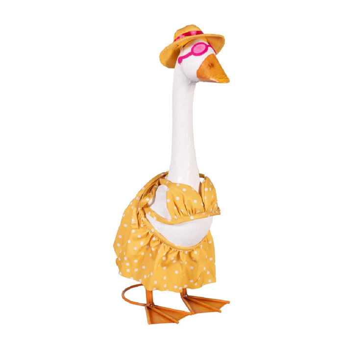 A duck in a fashionable dress and hat is situated in a garden, adding charm to the floral backdrop.