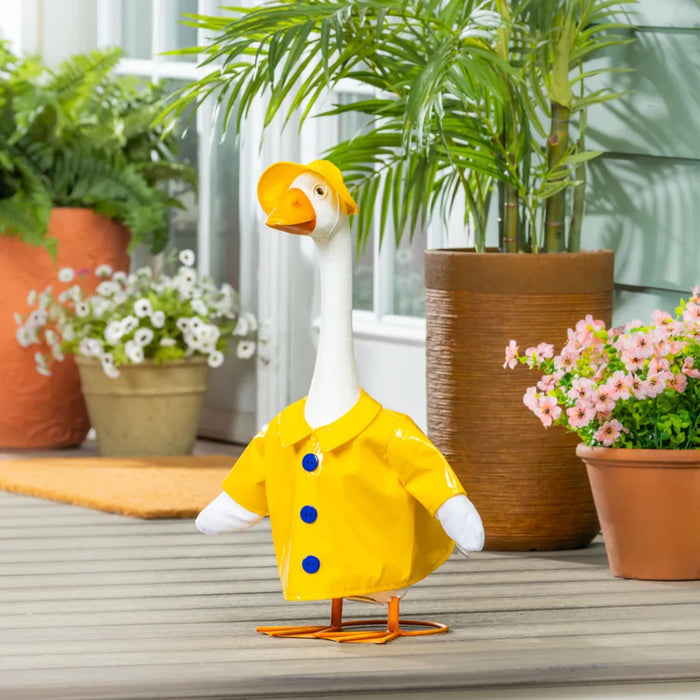 A duck in a bright raincoat stands on a porch, looking curiously at its surroundings.