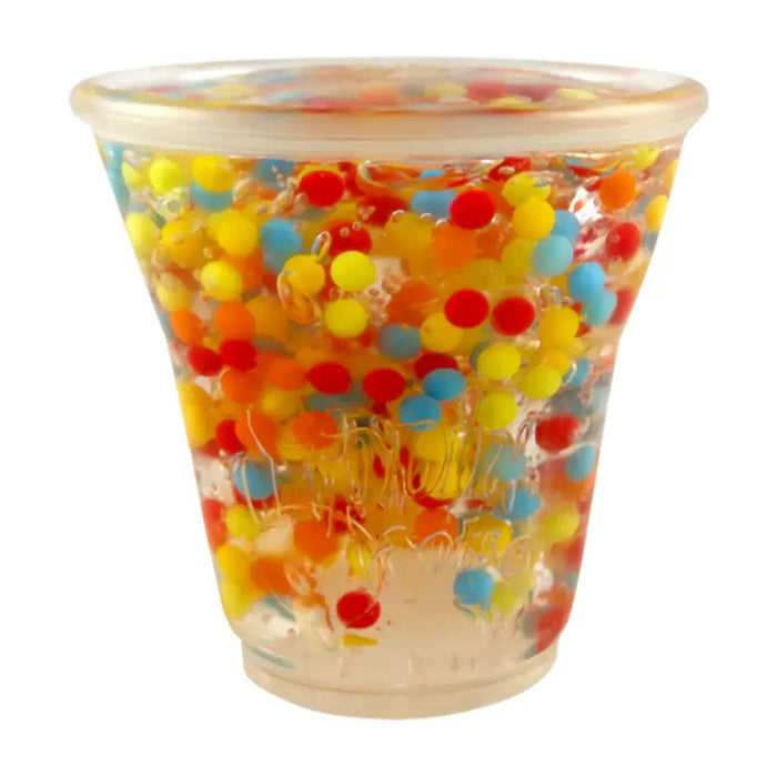 Clear cup filled with colorful water beads on a white background