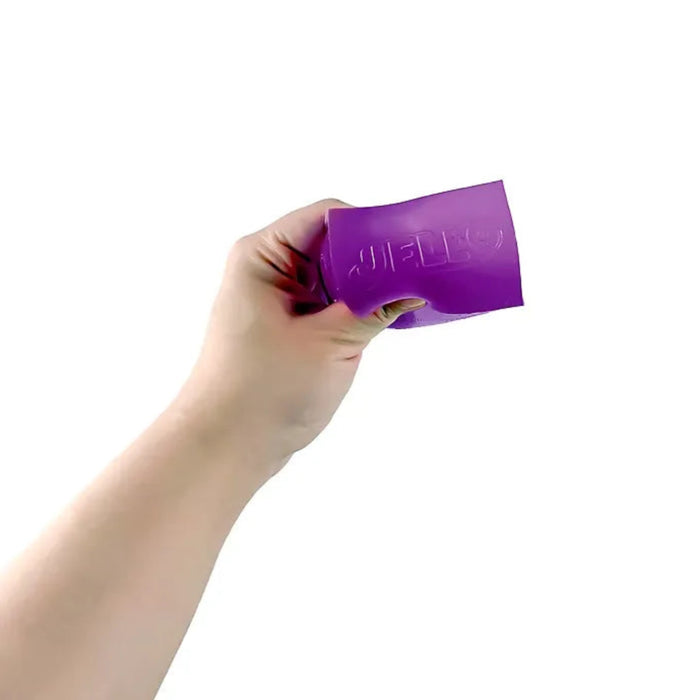 Hand squeezing a purple rectangular Jell-O Squishi toy, bending the soft sides around the embossed Jell-O logo.