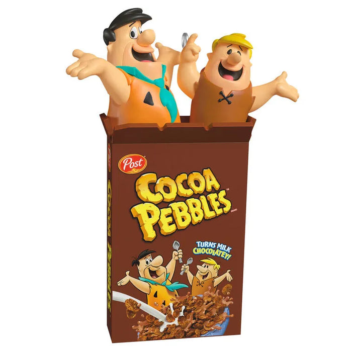 Front view of plastic 2026 Hallmark Keepsake Cocoa Pebbles ornament with Fred and Barney emerging from brown cereal box