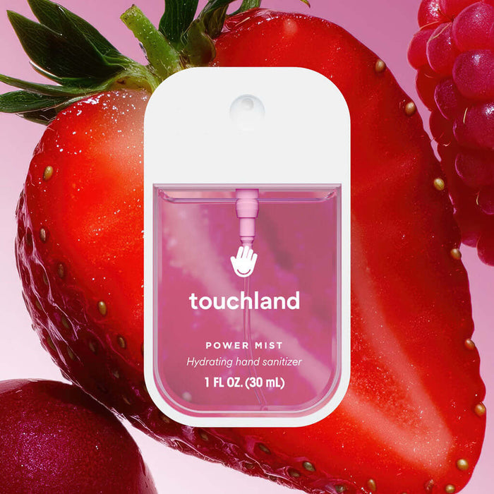 Touchland Berry Bliss hand sanitizer packaging with strawberries on a pink background
