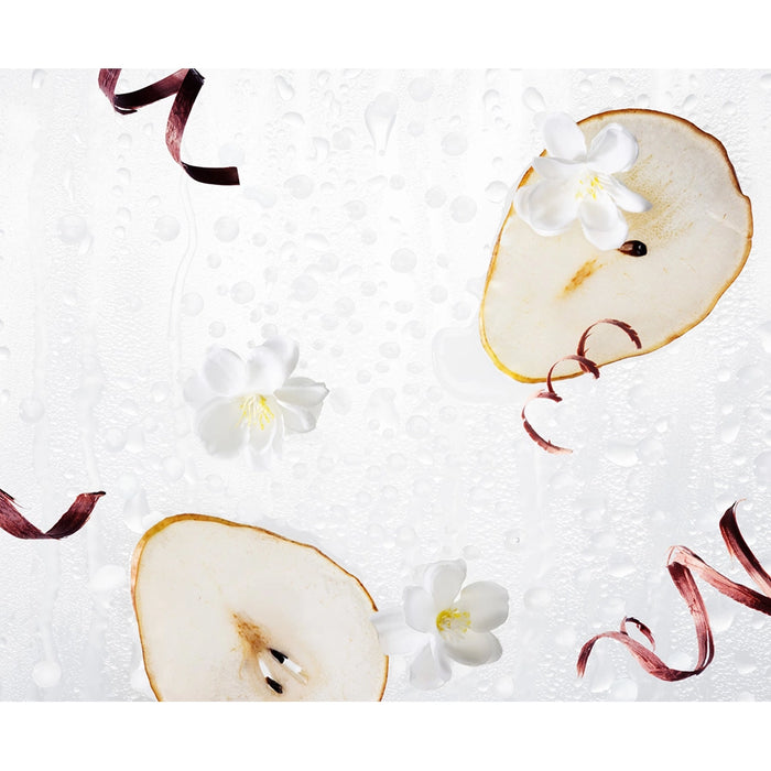 Sliced pears with flowers and ribbons on a textured white background